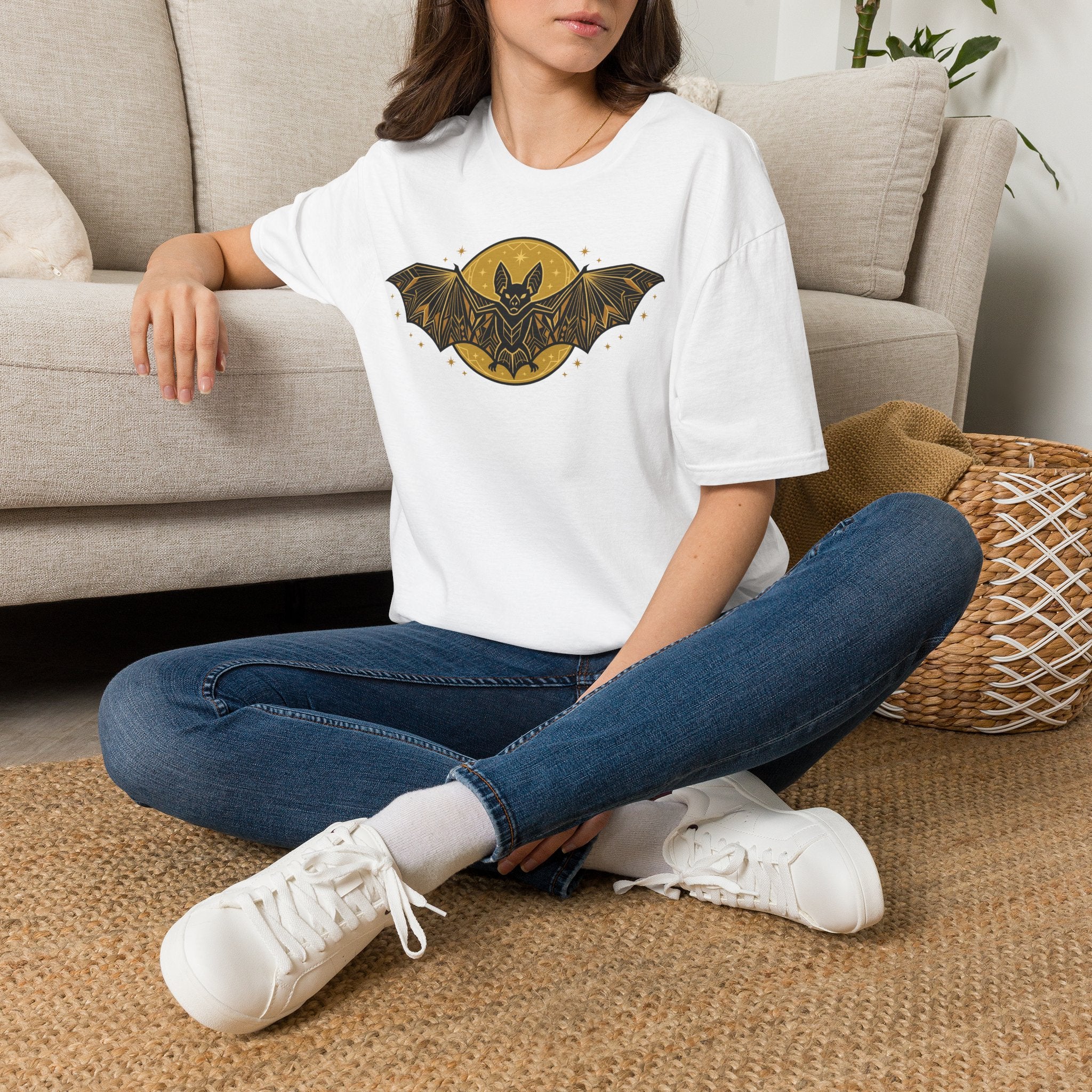 White crew-neck t-shirt with gold bat-and-moon graphic on the front