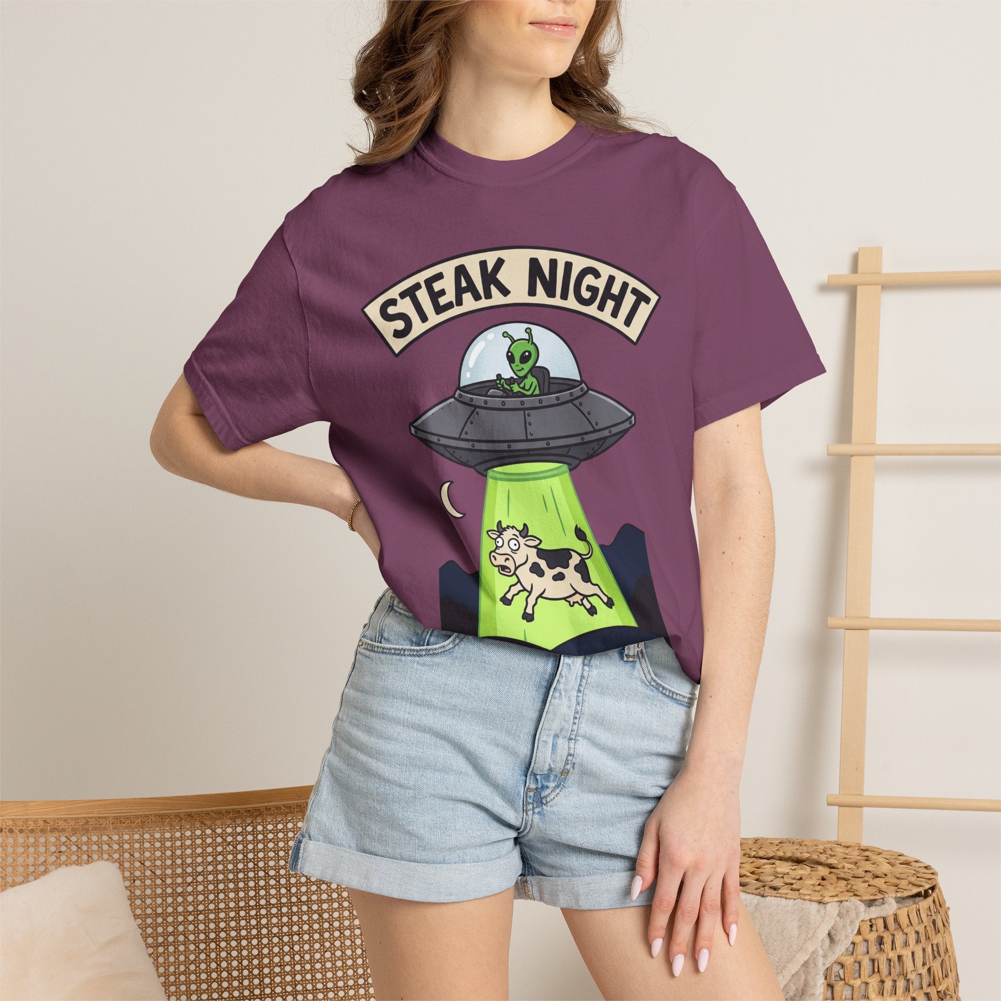 Purple T-shirt worn by model with Steak Night alien UFO and cow graphic