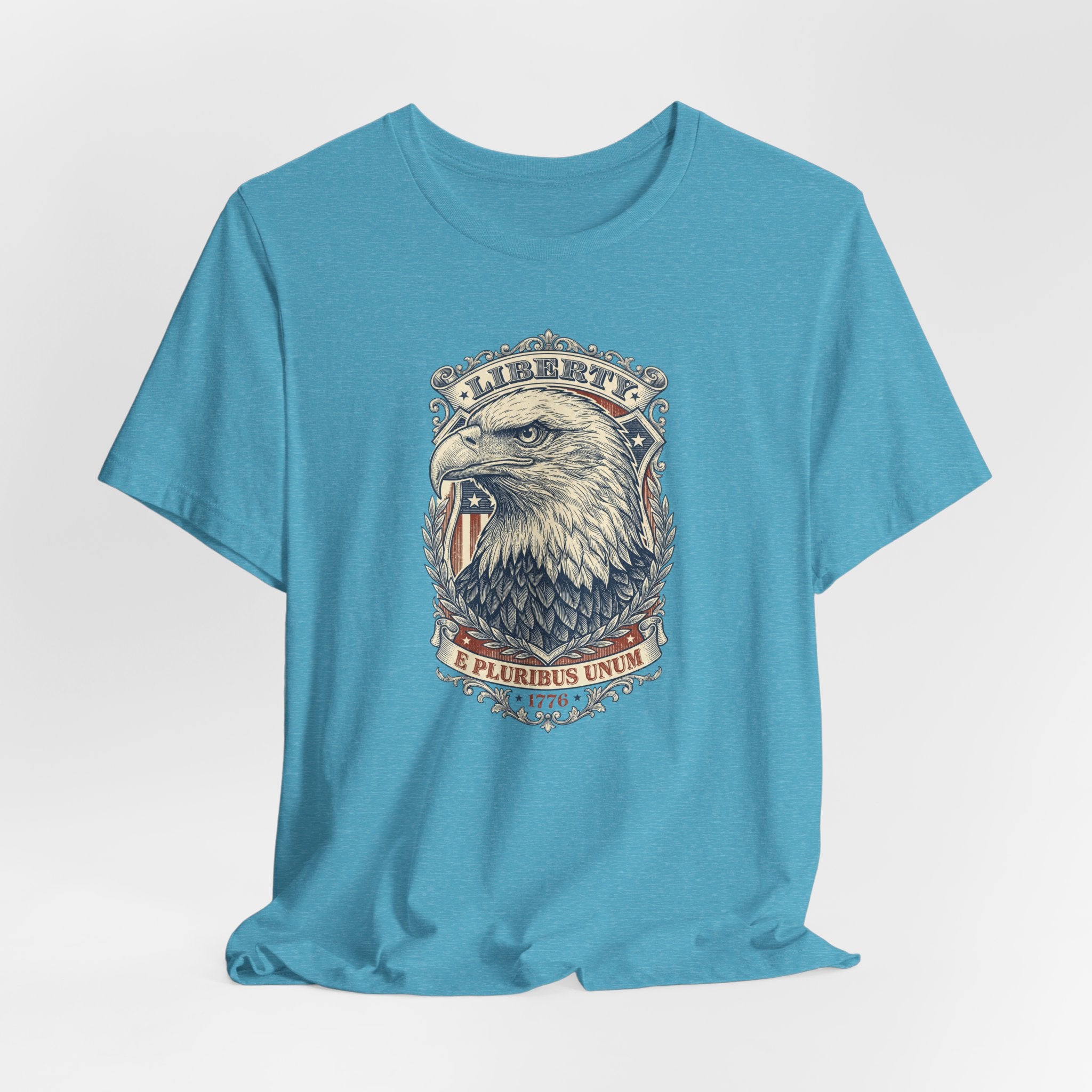 Teal crewneck t-shirt with eagle head graphic and emblem at center front.