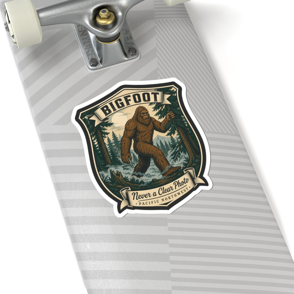 Bigfoot hiking badge sticker on notebook page, shield logo with brown Sasquatch