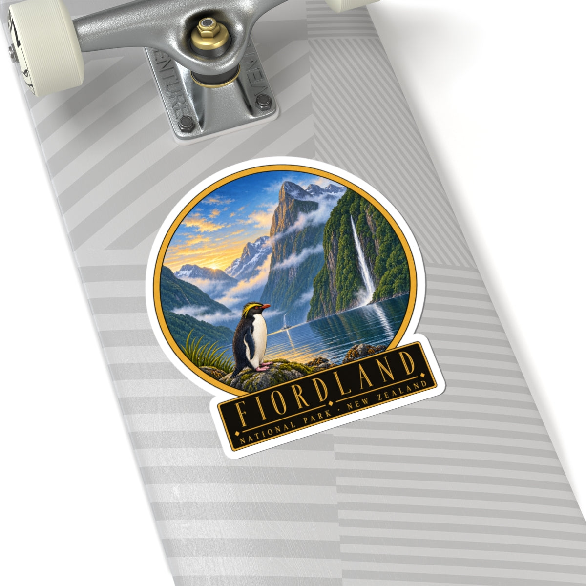 Vinyl sticker on suitcase: round penguin-and-waterfall view with FIORDLAND National Park text