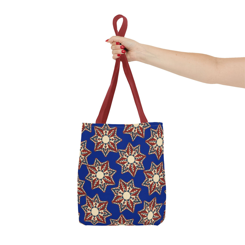 Blue tote bag with starburst floral pattern and red handles, top held up