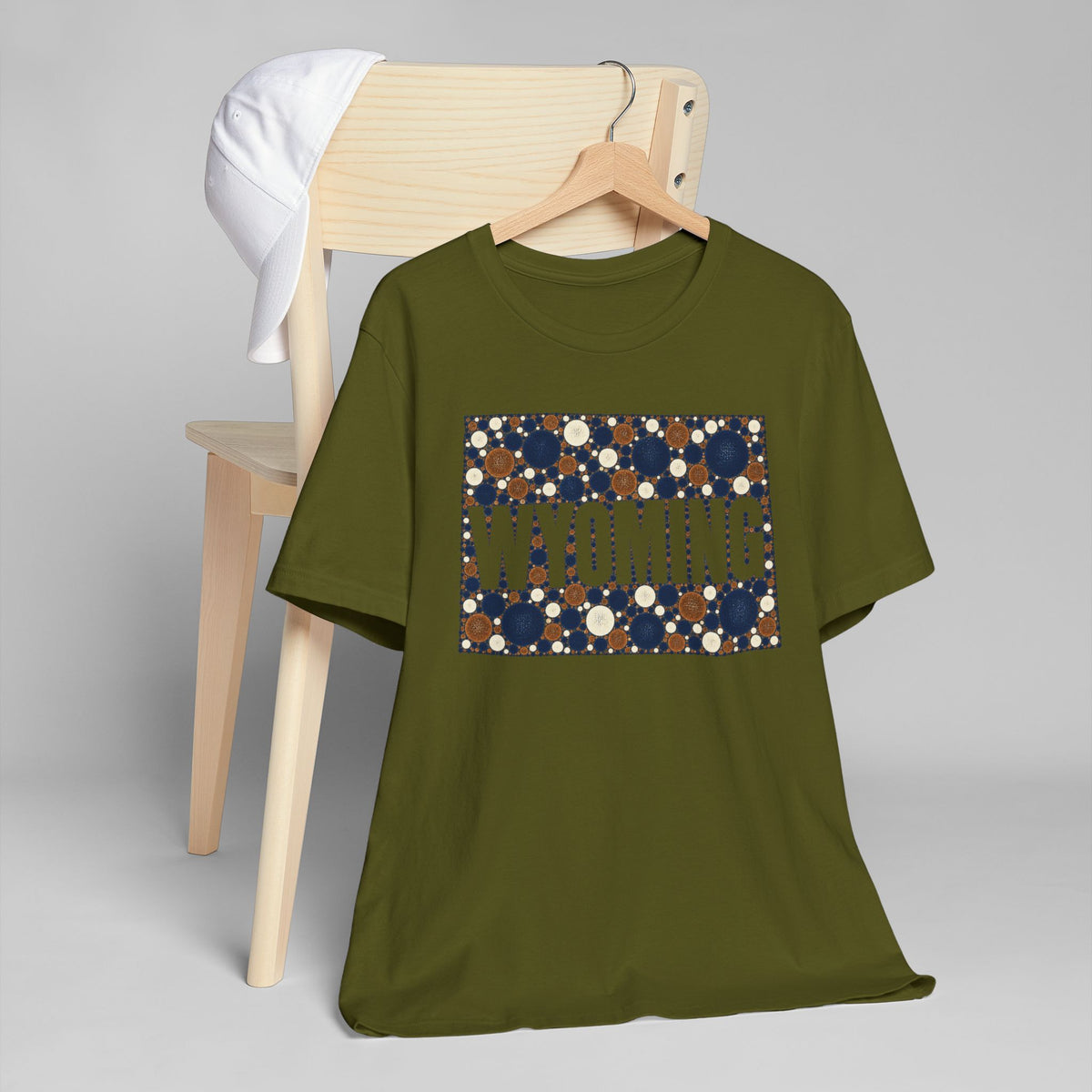 Olive crewneck T-shirt with front graphic rectangle of blue-brown polka dots.