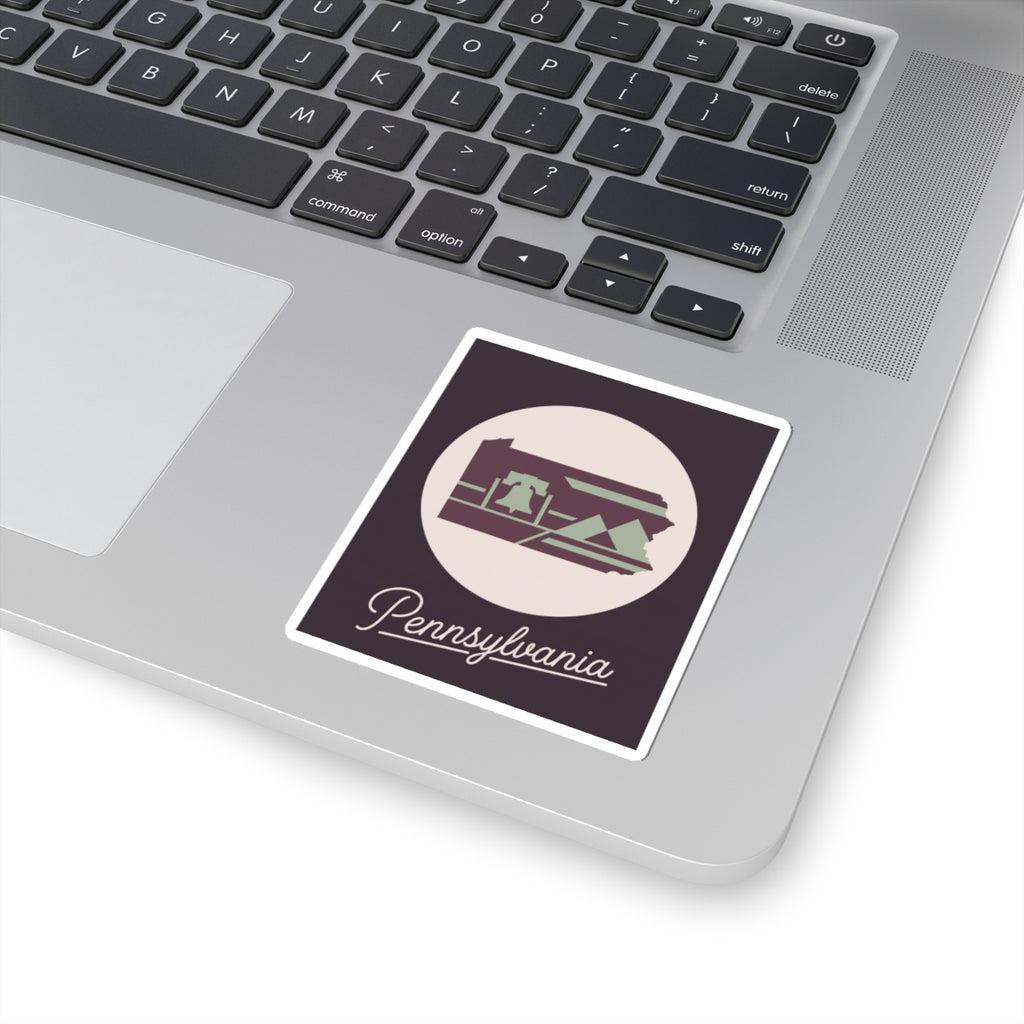 Pennsylvania state silhouette sticker on laptop lid, purple and green with “Pennsylvania” script