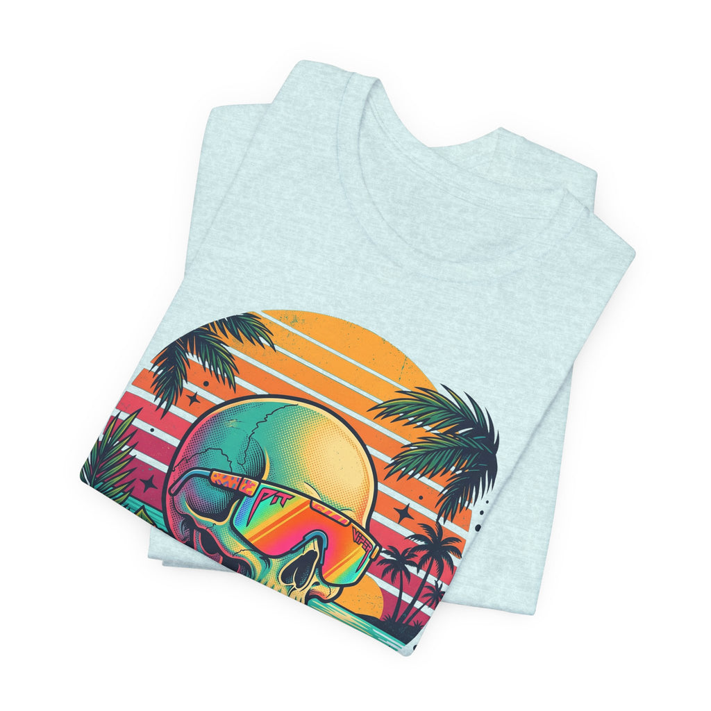 Light blue T-shirt folded with tropical skull, rainbow sunglasses, and palm tree sunset print