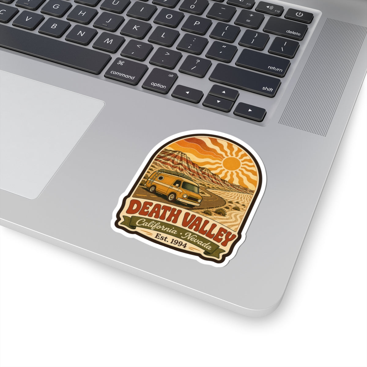 Kiss-cut sticker on laptop keyboard with yellow camper van and Death Valley Est. 1994 text